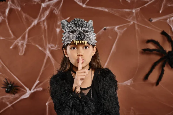 Nahaufnahme preteen girl shushing im schwarzen outfit mit wolfmaske, Halloween-konzept — Stockfoto