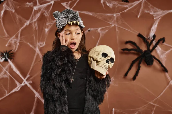 Close up aterrorizado preteen menina vestindo máscara lobo segura crânio em suas mãos, conceito de Halloween — Fotografia de Stock