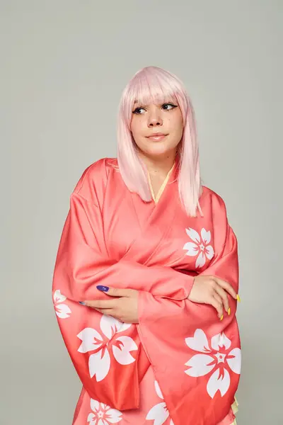 Blonde woman with colorful manicure posing in pink kimono with floral print on grey, anime style — Stock Photo