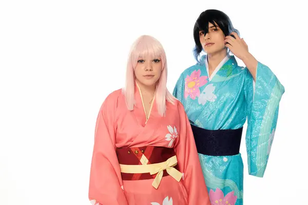 Молодая пара косплея в красочных кимоно и париках, смотрящая в камеру на белом, горизонтальном баннере — стоковое фото