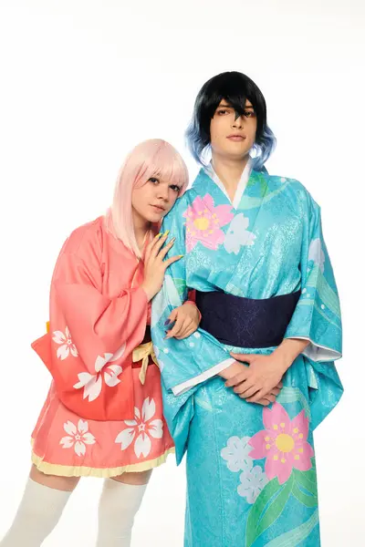 Blonde Frau im Anime-Stil lehnt sich an extravaganten Mann in buntem Kimono auf weißen, Cosplay-Figuren — Stockfoto