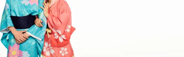 Обрезанный вид молодых косплееров в красочных японских кимоно на белом, горизонтальном баннере — стоковое фото