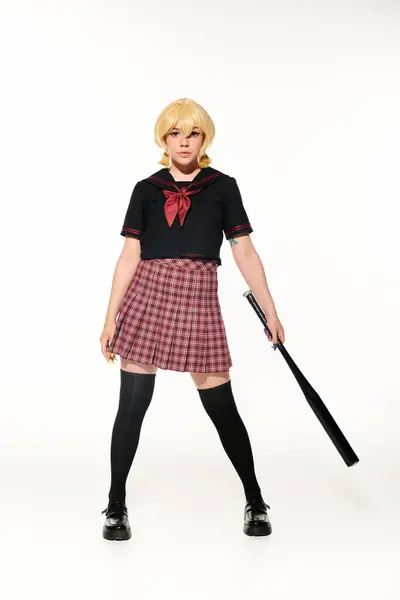 Full length of confident female cosplayer in school uniform posing with baseball bat on white — Stock Photo