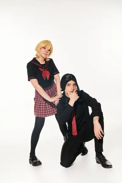Anime stile studenti in scuro uniforme e parrucche guardando fotocamera su bianco, asiatico cosplay sottocultura — Foto stock