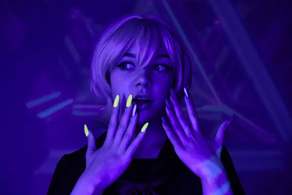 Amazed blonde woman with fluorescent manicure in blue neon light on abstract backdrop, anime style — Stock Photo