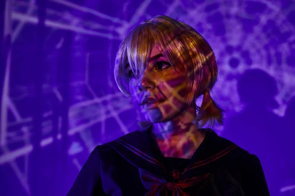 Portrait of anime woman in blonde wig in abstract projection on blue neon backdrop, fusion style — Stock Photo