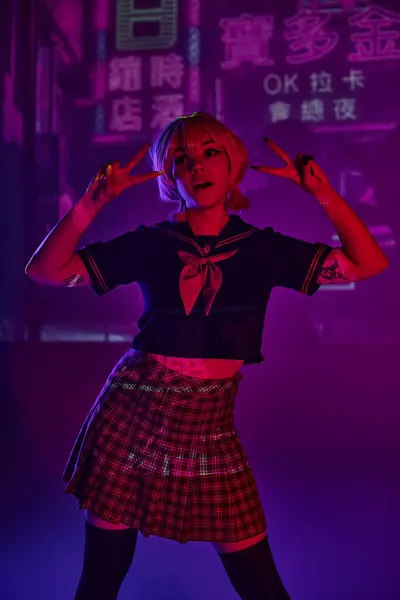 Anime donna in uniforme scolastica che mostra segni di vittoria su sfondo viola al neon con geroglifici — Foto stock