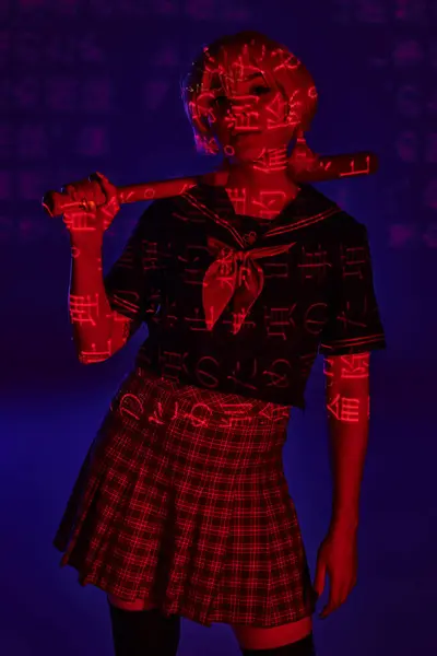 Young anime woman in school uniform with baseball bat in red neon light with hieroglyphs on blue — Stock Photo