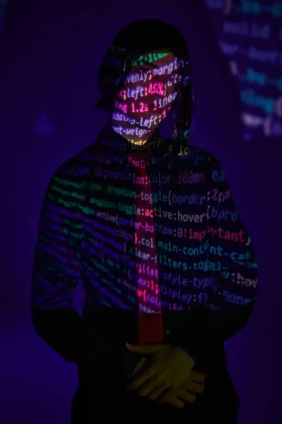 Young student in uniform in neon light with programming symbols on dark blue backdrop, cosplayer — Stock Photo