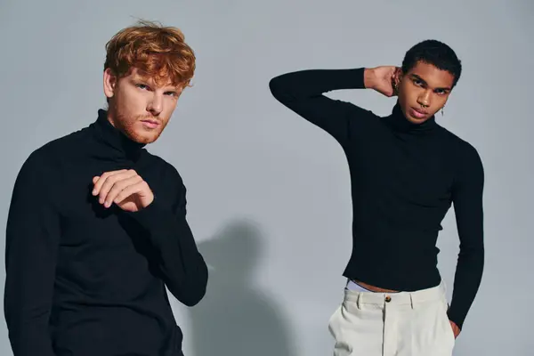 Deux modèles masculins multiraciaux avec accessoires en col roulé noir gesticulant et regardant une caméra — Photo de stock