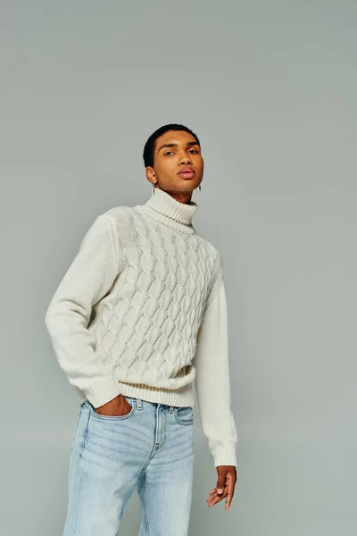 Appealing african american man with accessories in white sweater looking at camera, fashion concept — Stock Photo