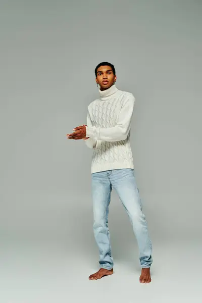 Good looking african american man in white sweater with accessories posing on gray backdrop, fashion — Stock Photo