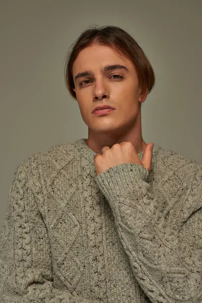 Портрет молодого привабливого чоловіка в комфортному теплому светрі позує і дивиться на камеру, мода — стокове фото
