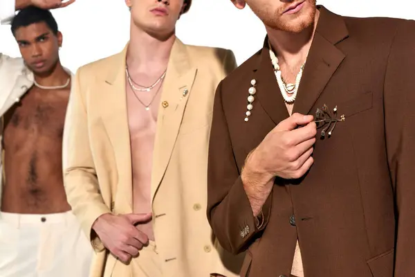 Cropped view of two stylish men in unbuttoned suits with elegant african american man on backdrop — Stock Photo