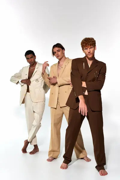Jovem trio multicultural em ternos elegantes com acessórios posando em pano de fundo branco, conceito de moda — Fotografia de Stock