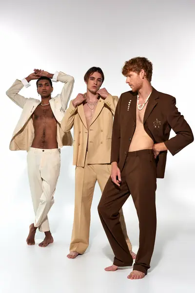 Tiro vertical de grupo diversificado de homens em ternos vibrantes com acessórios posando em pano de fundo branco — Fotografia de Stock