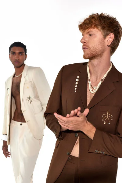 Vertikale Aufnahme von gut aussehenden interrassischen Duo posiert in stilvollen Anzügen mit Accessoires, Männer-Power — Stockfoto