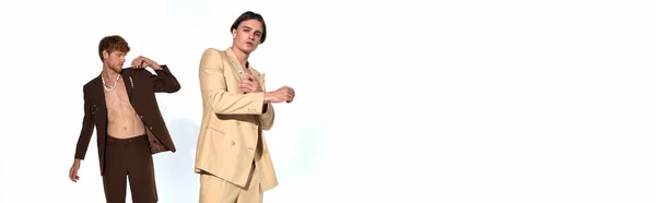 Appealing young man in beige suit posing with other male model in unbuttoned suit, men power, banner — Stock Photo