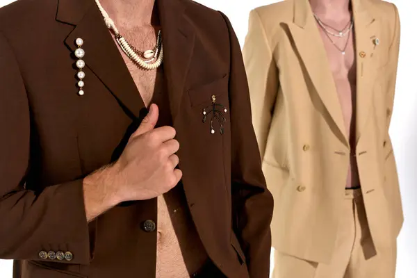 Cropped view of young male models in elegant unbuttoned suits posing on white backdrop, men power — Stock Photo
