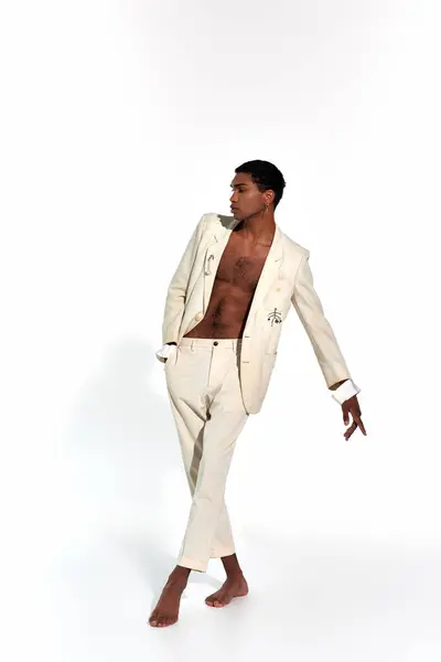Appealing sexy african american man in elegant suit in motion on white backdrop, fashion concept — Stock Photo
