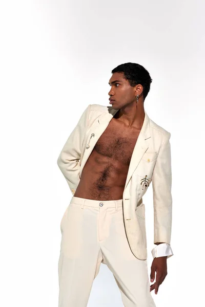 Bonito afro-americano homem de terno dobrando seu corpo ligeiramente e olhando para longe, conceito de moda — Fotografia de Stock