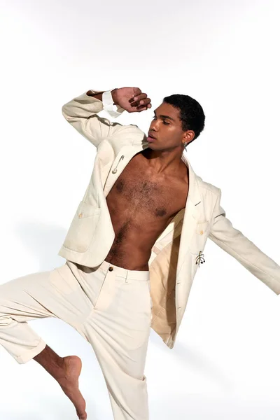 Afroamericano giovane bel modello maschile in elegante abito in posa in movimento con gamba e braccia sollevate — Foto stock
