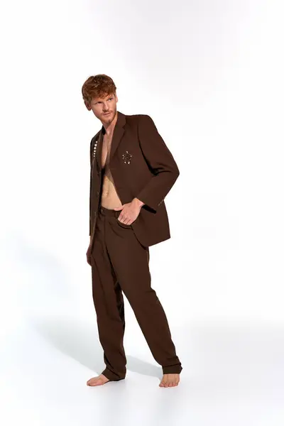 Vertical shot of young man in elegant suit posing on white backdrop looking away, fashion concept — Stock Photo