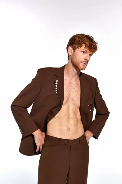 Handsome elegant man posing in unbuttoned suit on white backdrop, looking away, fashion concept — Stock Photo