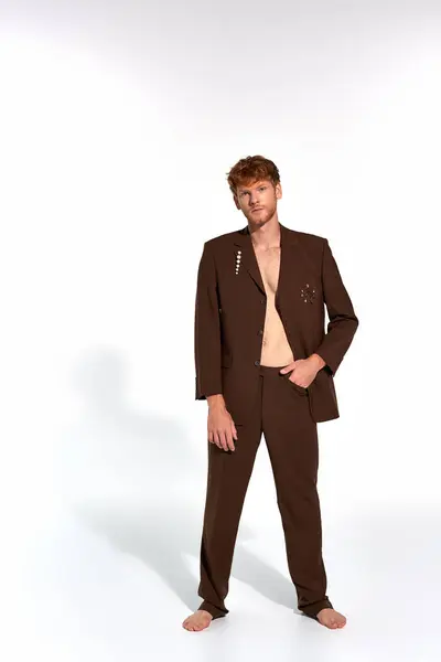 Homem elegante de boa aparência em terno elegante marrom com acessórios olhando para a câmera, moda — Fotografia de Stock