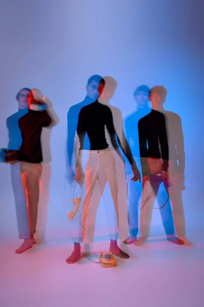 Три багатоетнічні чоловічі моделі в чорному одязі з ретро-телефонами, довга експозиція, чоловіча влада — стокове фото