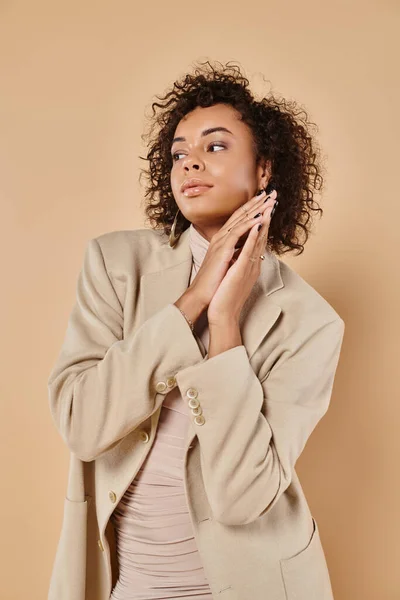 Autumn trends, brunette african american woman posing in turtleneck and blazer on beige backdrop — Stock Photo