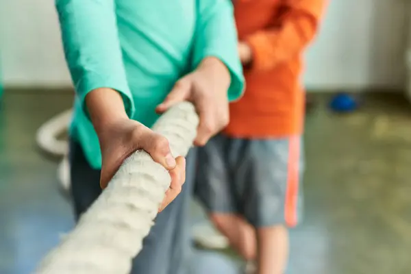 Ausgeschnittene Ansicht von zwei Kindern in Sportbekleidung beim Ziehen eines Fitnessseils in der Turnhalle, Kindersport — Stockfoto