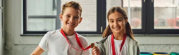 Cute girl with medal holding jump rope and cute boy posing with soccer ball, child sport, banner — Stock Photo