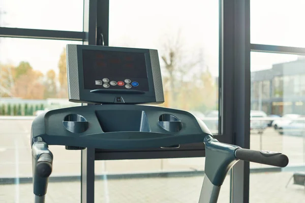 Photo of black modern treadmill indoors in gym with window on backdrop, sport concept — Stock Photo
