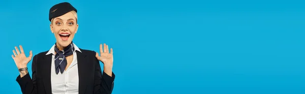 Ritratto di hostess stupita in uniforme mostrando gesto wow su sfondo blu, banner — Foto stock