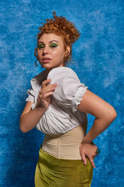 Donna rossa alla moda in camicetta bianca guardando la fotocamera su sfondo blu strutturato, più tendenza dimensioni — Stock Photo