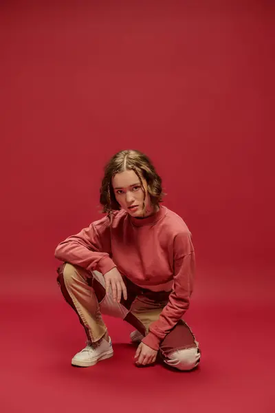 Самовираження, стильний ген Z дівчина в клаптикових штанях і обрізаний довгий рукав на червоному тлі — стокове фото