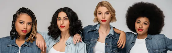 Group portrait of stylish multiethnic girlfriends in blue denim clothes on grey, horizontal banner — Stock Photo