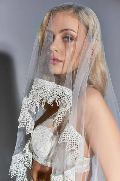Tiro vertical de mulher sexy atraente em lingerie sedutora branca com véu olhando para a câmera — Fotografia de Stock