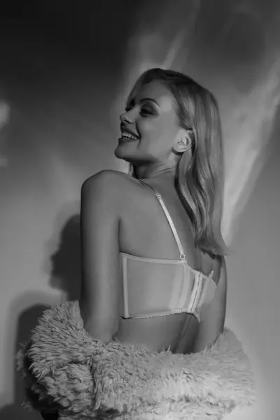 Preto e branco tiro de alegre sedutor mulher no sexy lingerie e falso pele virando cabeça ligeiramente — Fotografia de Stock