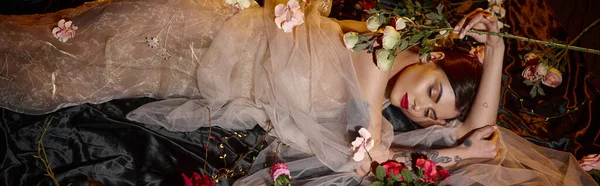 Attraktive sinnliche junge Frau in romantischem transparentem Kleid zwischen blühenden Blumen liegend, Banner — Stockfoto