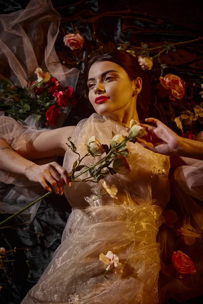 Женская элегантность, мечтательная молодая женщина в романтическом прозрачном платье, лежащем среди красивых цветов — стоковое фото