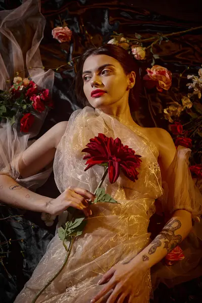 Жіночна елегантність, чарівна жінка в романтичному прозорому платті, що лежить серед красивих квітів — стокове фото