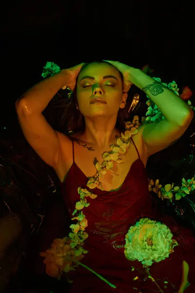 Green light, attractive young woman with wet hair posing with closed eyes among blooming flowers — Stock Photo