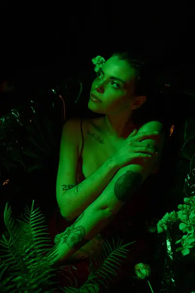 Luz verde, jovem atraente com cabelo molhado posando na banheira entre as flores, corpo molhado — Fotografia de Stock