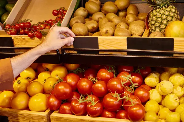 Vista recortada de vendedor varón maduro poniendo precio etiqueta en el puesto de comestibles con frutas y verduras - foto de stock
