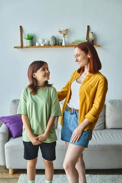 Happy mother and teenage daughter smiling at each other at home in living room, love and care — Stock Photo