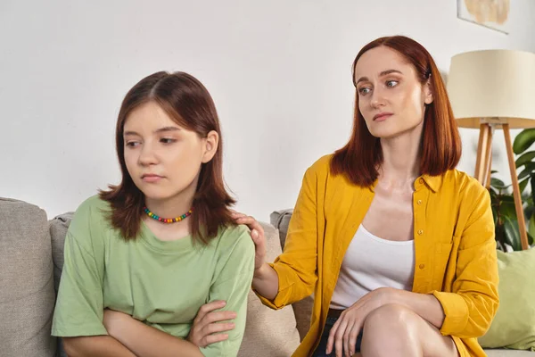 Caring mother calming frustrated teenage daughter on couch in living room, supportive parent — Stock Photo
