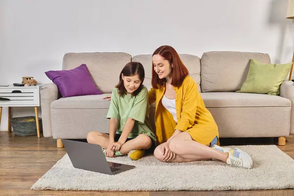 Усміхнена мати і дочка-підліток дивиться фільм на ноутбук на підлозі у вітальні, дозвілля — стокове фото
