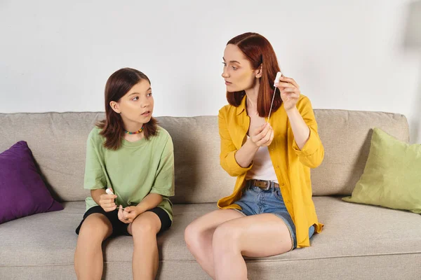 Mother showing menstrual tampons to teenage daughter during sex education at home, feminine care — Stock Photo